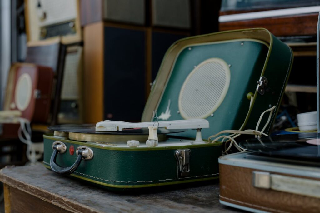A classic green vintage turntable displayed among other retro audio equipment.